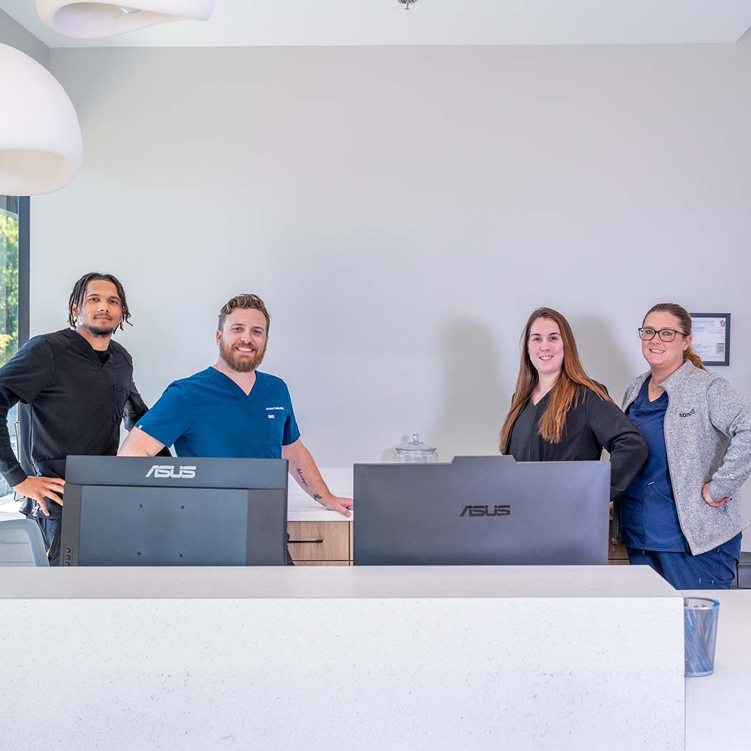 Animal Hospital of Valencia team posing for a photo at the front desk